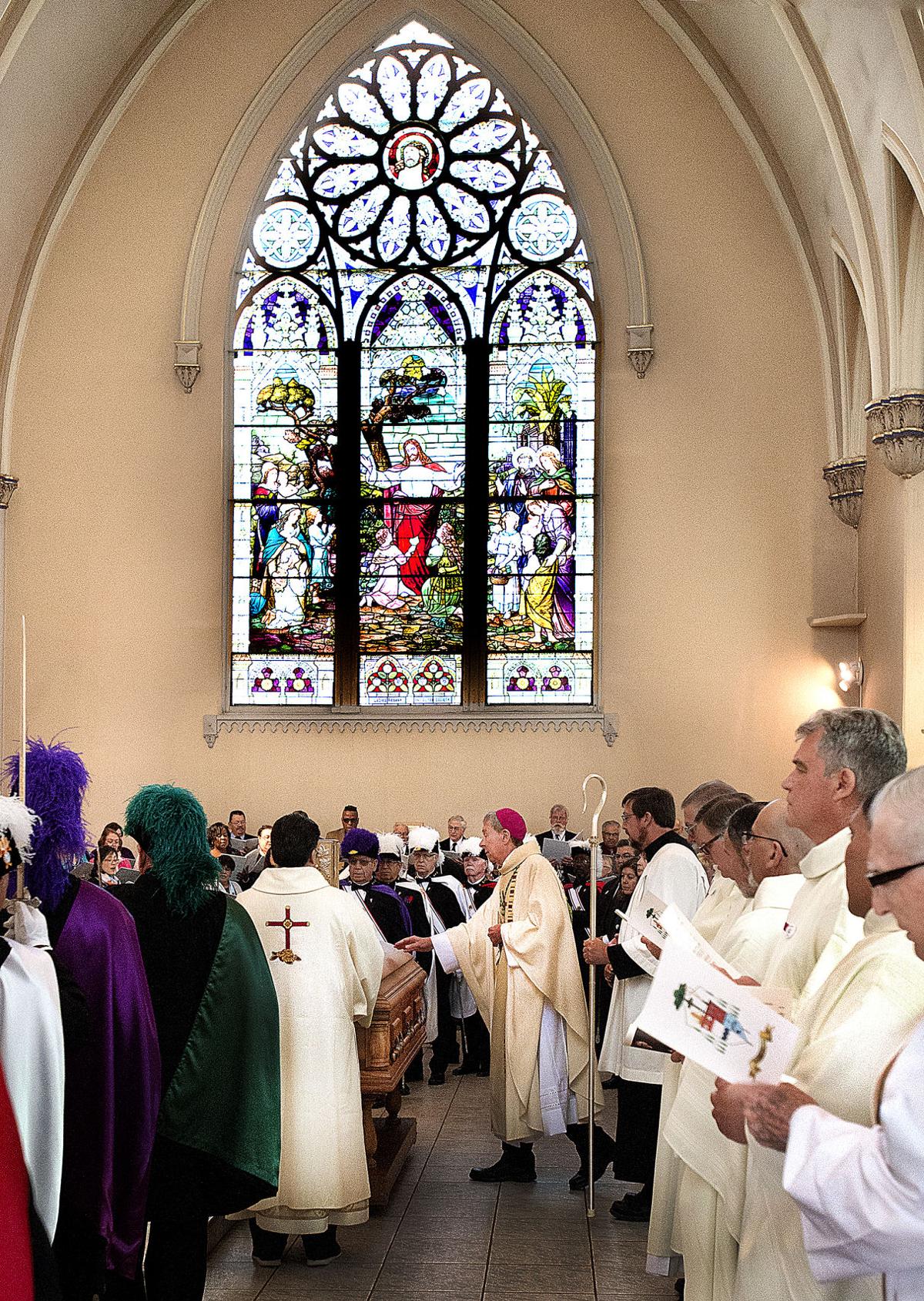 Bishop Stephen Berg (center), surrounded by other Bishops and clergy members, touches the coffin of Bishop Arthur N. Tafoya at the start of his funeral Mass